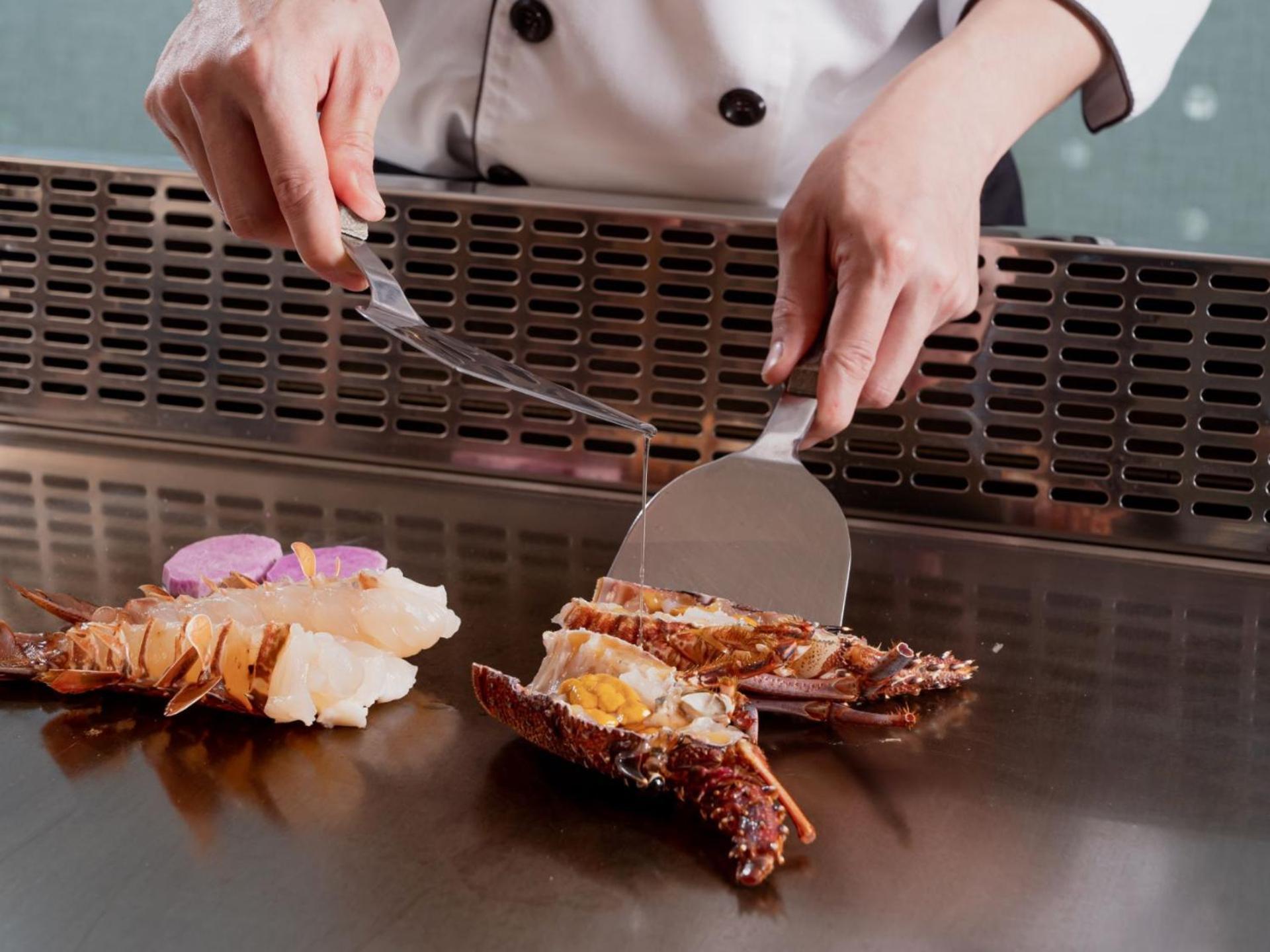 فندق ويندسور تايتشونغ المظهر الخارجي الصورة A chef using a fish knife to fillet a lobster